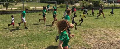 Local school children participate in a Physical Education class run by volunteers in Belize. A group of volunteers in Belize run a sports coaching class at a local school.